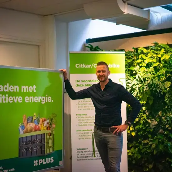 Jack Van Nrg Office Naast Een Banner Van De Plus (1)