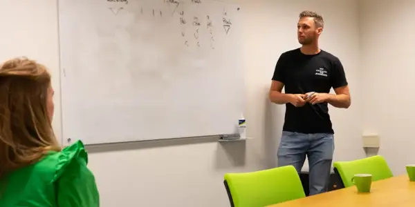 Supply Chain Specialist Cees Legt Wat Uit Aan Een Andere Collega Van Nrg Office Met Whiteboard