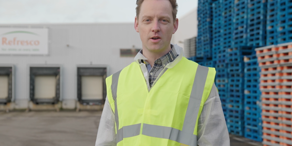 Supply Chain Manager Robin Spreekt In De Camera Met Achter Hem De Business Van Refresco