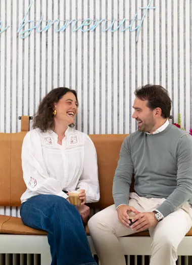 Twee Mensen Van Nrg Office Staan Lachend Voor Het Pand